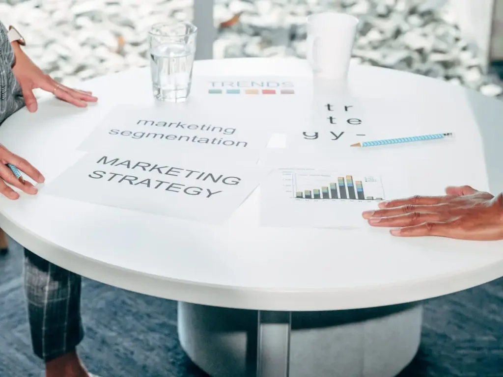 Dua profesional membahas strategi segmentasi pasar di meja rapat